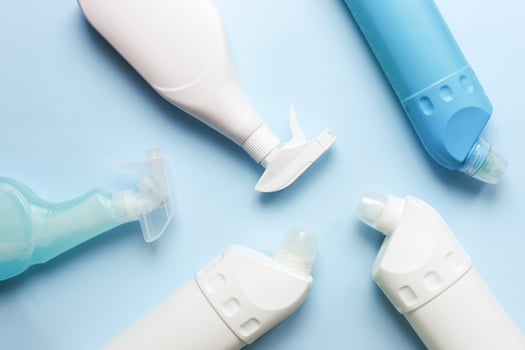 Flat lay cleaning products. Cleaning bottle mockup. Sprays for cleanliness on a blue background photo