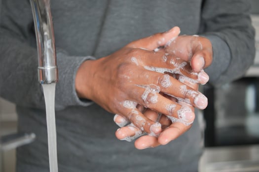 young man washing hands with soap warm water photo