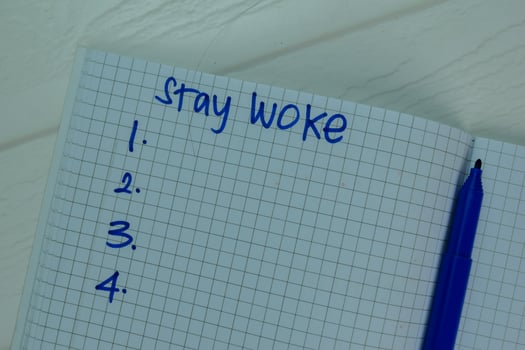 Stay Woke write on a book Supported by an additional services isolated on office desk. photo