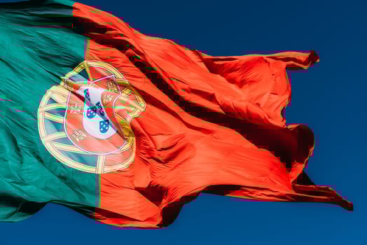 Portugal flag isolated on the blue sky waving in the wind photo