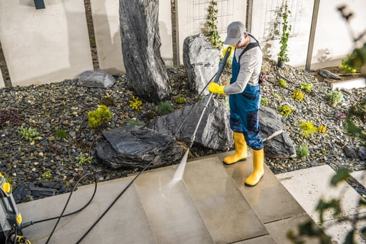 Worker Cleaning the Yard Around the House photo