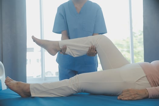 young asian physical therapist working with senior woman on walking with a walker photo