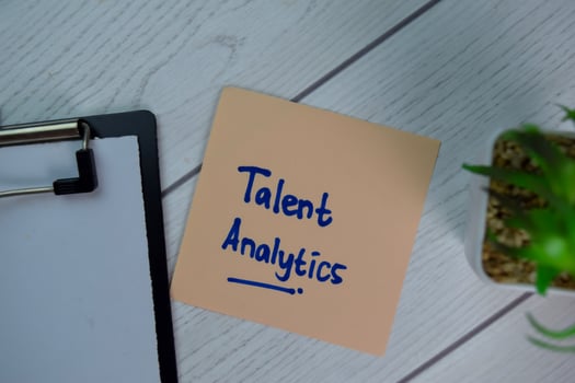 Talent Analytics write on sticky notes isolated on Wooden Table. photo