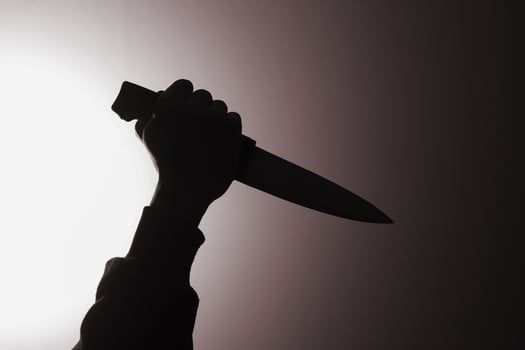 Close up of male hand holding a knife to stab someone. Crimes and criminality concept photo