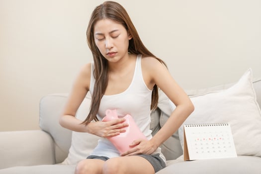 Menstruation, period cycle of monthly, hurt asian young woman, female hand in stomachache, suffer from premenstrual, belly or abdomen pain, using hot water bottle. Health problem Inflammation in body. photo