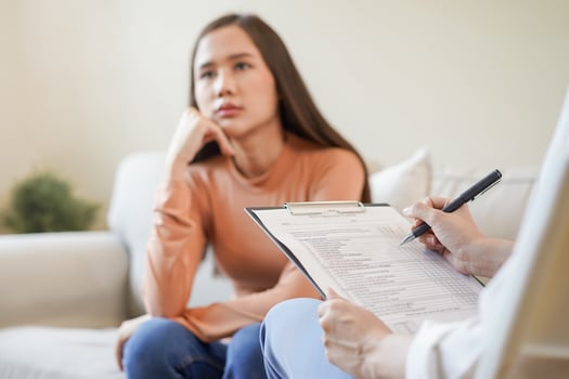 Psychology, depression. Sad, suffering asian young woman consulting with psychologist, psychiatrist while patient counseling mental with doctor woman taking notes at clinic. Encouraging, therapy. photo