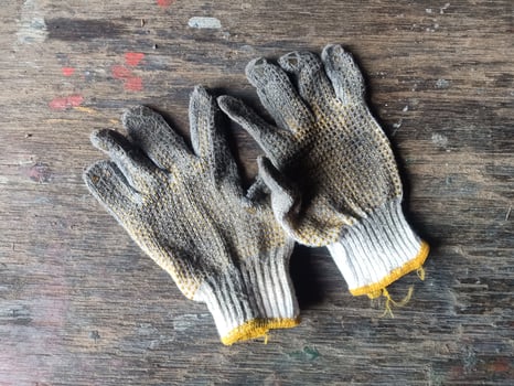 Used Construction work gloves, dirty glove on a wood background photo