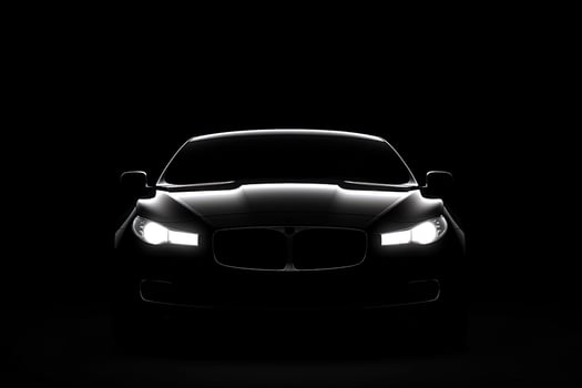 Front view dark silhouette of a modern luxury black car isolated on black background. photo