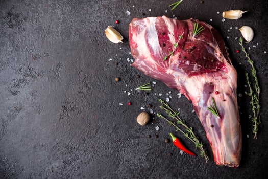 Raw fresh Lamb Meat shank and seasonings on black stone background photo