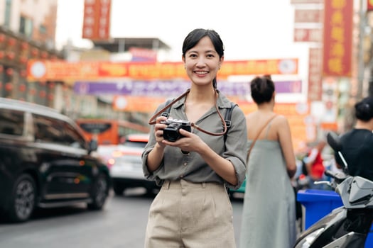 Young Asian woman backpack traveler enjoying China town street food market in Bangkok, Thailand. Traveler checking out side streets. photo