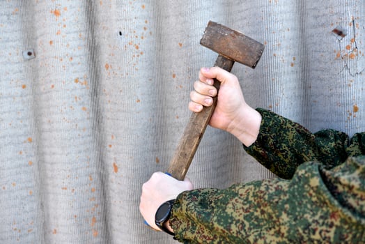 A sledgehammer in the hands of a man. A large hammer in his hands. photo