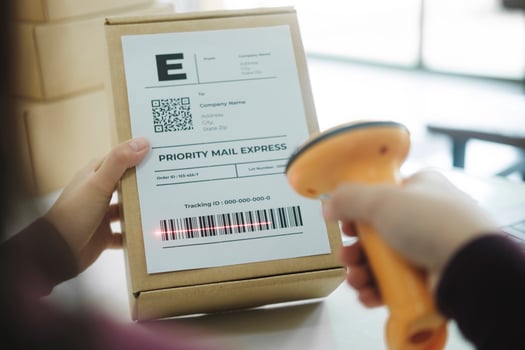 Female online business owner scan shipping label on parcel. photo