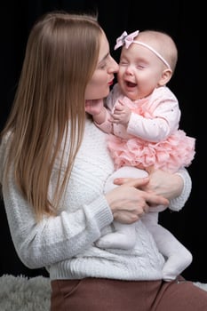 Mom holds her little daughter in her arms. Motherhood. photo