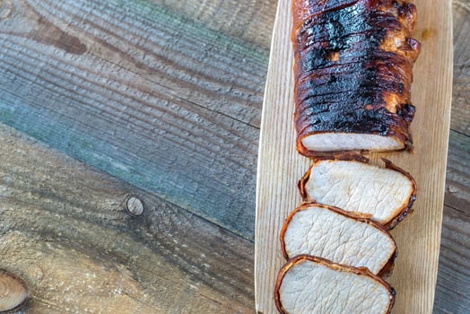 Pork loin wrapped in bacon on the wooden board photo