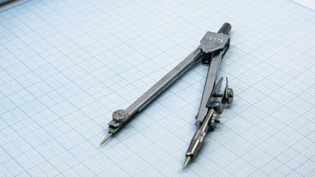 Drawing compass isolated on graph paper photo