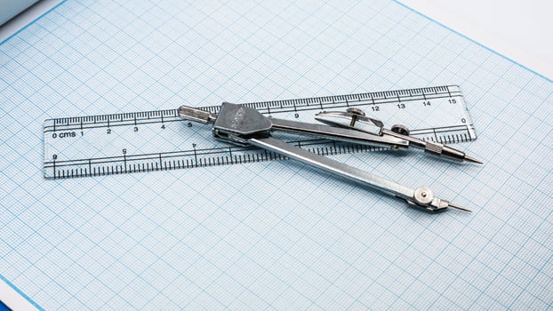 Drawing compass isolated on graph paper photo