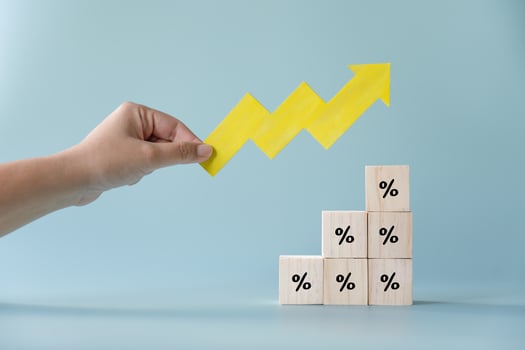 Yellow paper cut arrow going up positive trend on wooden blocks with percentages. Concept of profit increasing in percentage. photo