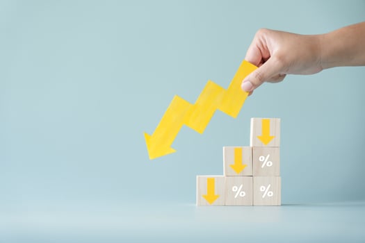 Yellow paper cut arrow going down negative trend on wooden blocks with percentages. Concept of profit decreasing in percentage. photo
