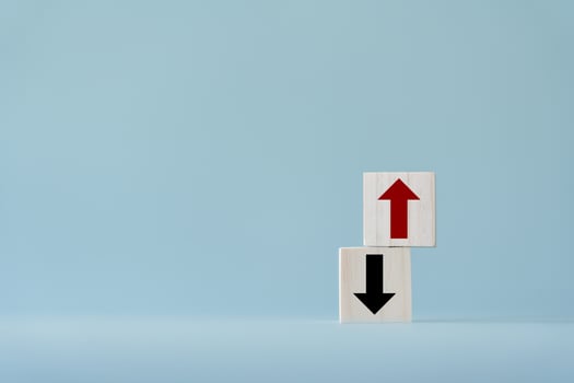 Up and down turn arrow on wooden blocks difference direction to earn or to loss. Red arrow as positive and black as negative movement idea. photo
