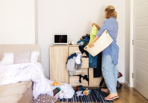 woman entered her child's room with a mess to collect dirty things and clean up photo