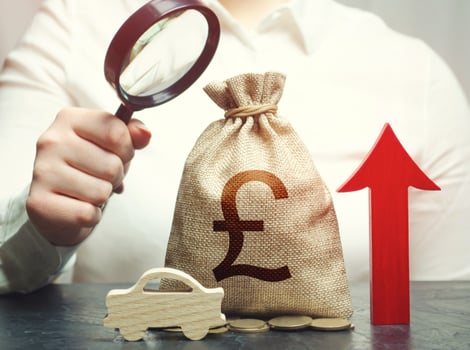 A woman inspects a british pound sterling money bag and a car. Growing sales. Electric vehicle support subsidies. Expensive car maintenance. High price of insurance. ICE. Rise of fuel excise taxes. photo