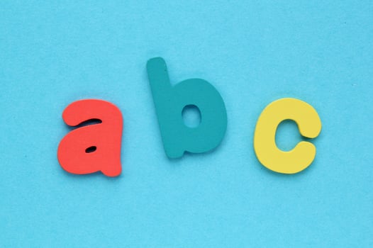 Alphabet wooden colored letters on blue background. Education and back to school concept. Foreign languages study. Kindergarten, preschool learning banner photo