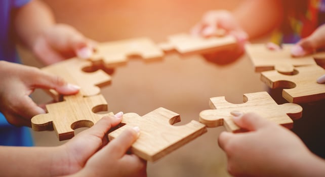 jigsaw in hand puzzle pieces gather together teamwork The concept of planning work as a team. photo