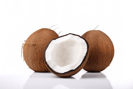 a whole and a half coconut on a white surface. photo