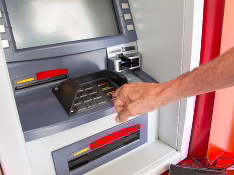 Close up of a man withdrawing money from an ATM photo