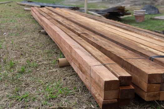 Wood timber construction material. Closeup big wooden boards. Stacked wooden beams of square section for house construction photo