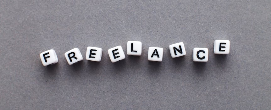 word freelance made from plastic cubes of beads on gray background. banner photo