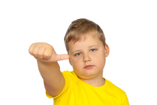 A boy in a yellow T-shirt on a white background points his fingers at a neutral rating. The concept of a banner with information. Space for the text. photo