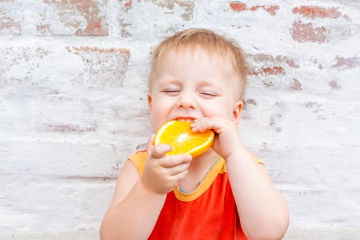 Portrait of child. Cute boy posing with an orange. The emotions of a child. photo