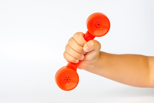 Red toy phone in the child's hand. Close-up of a child's hand. Isolated on a white background. The concept of an advertising banner. photo