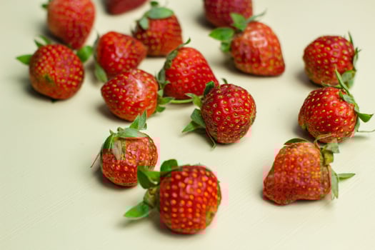 close up of strawberries on a pastel yellow background photo