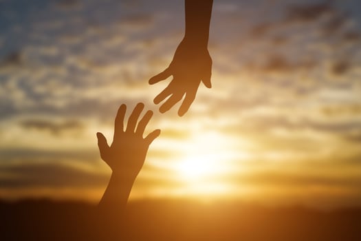 Silhouette of reaching, giving a helping hand, hope and support each other over sunset background. Help concept photo