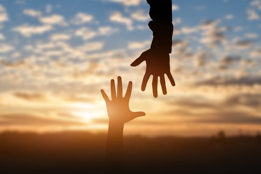 Silhouette of reaching, giving a helping hand, hope and support each other over sunset background. Help concept photo