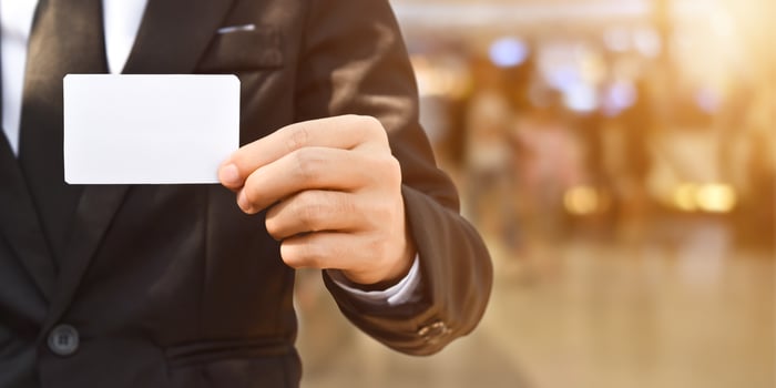 Businessman showing a blank piece of paper. Any business cards design ideas. photo