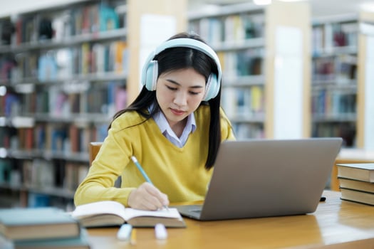 Student studying at library with laptop. photo