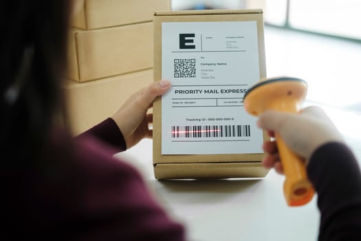 Female online business owner scan shipping label on parcel. photo