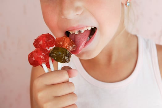 Child eats candy. Girl has caries on teeth. photo