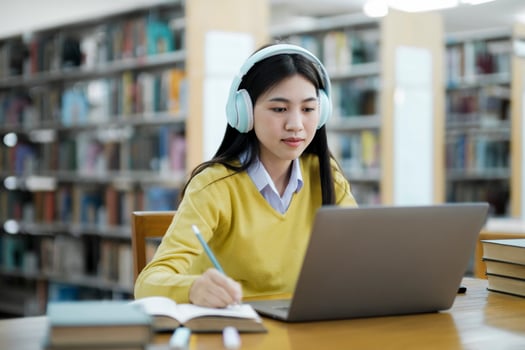 Student studying at library with laptop. photo