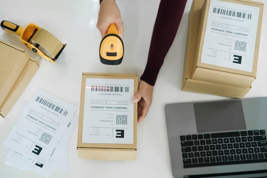 Female online business owner scan shipping label on parcel. photo