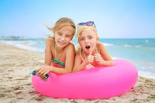 Happy girls lying on pink inflatable circle. photo