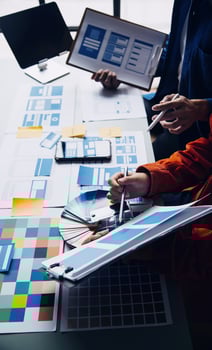 Close up ux developer and ui designer brainstorming about mobile app interface wireframe design on table with customer breif and color code at modern office.Creative digital development agency photo