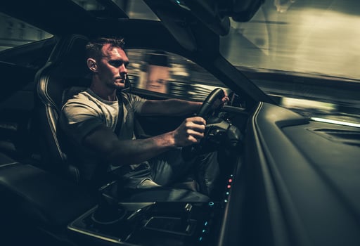 Man Driving Exotic Car At Night. photo