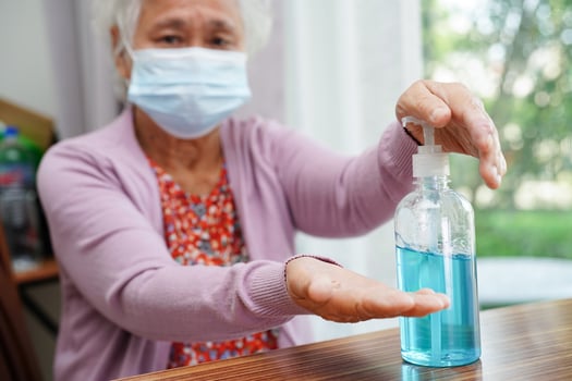 Asian senior woman press blue alcohol sanitizer gel for washing hand protect infection coronavirus. photo