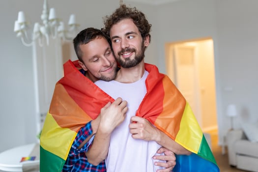 Affectionate Male gay couple indoors. Man embracing his boyfriend from behind at home. Gay couple celebrating pride month photo