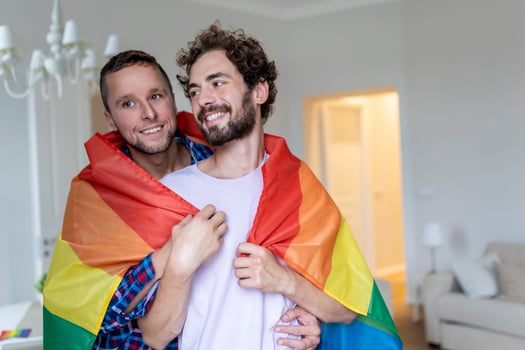 Affectionate Male gay couple indoors. Man embracing his boyfriend from behind at home. Gay couple celebrating pride month photo