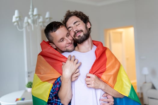 Affectionate Male gay couple indoors. Man embracing his boyfriend from behind at home. Gay couple celebrating pride month photo